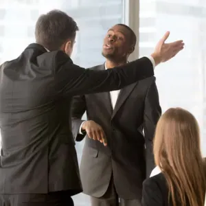 Two male professionals in a heated argument during a meeting while a colleague looks on San Diego courthouse for employment law cases