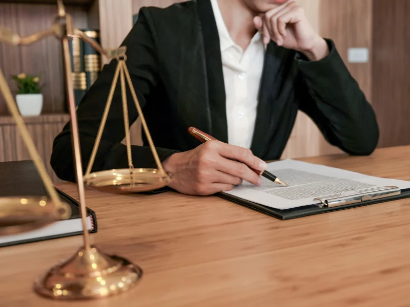 Lawyer reviewing legal documents with scales of justice on desk